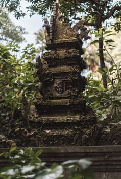 Stone curved balinese architecture. Close up shot of temple sculpture in sacred monkey forest on green nature background