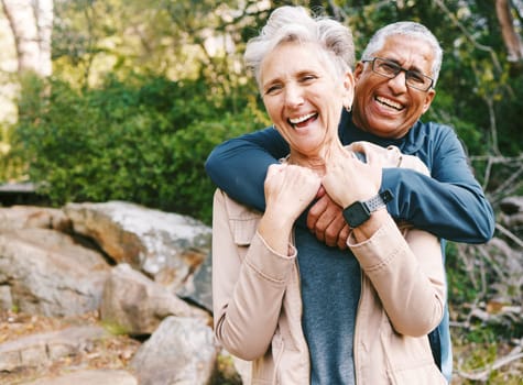 Hiking, laugh and romance with a senior couple hugging while in the woods or nature forest together in summer for a hike. Fun, joke and bonding with a mature man and woman enjoying retirement outdoor.
