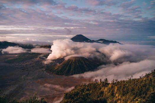 Landscape view of misty mount Bromo volcano. Foggy morning in the java national park with mount Semeru