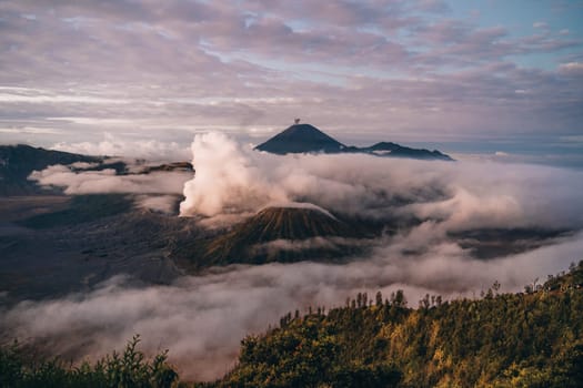 Landscape view of misty mount Bromo volcano. Foggy morning in the java national park with mount Semeru