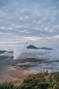 Landscape view of misty mount Bromo volcano. Foggy morning in the java national park with mount Semeru