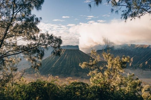 Landscape view of misty mount Bromo volcano. Foggy morning in the java national park with mount Semeru