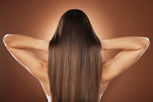 Woman, back or hair style on brown background in relax studio for keratin treatment, self care wellness or color dye routine. Model, texture or brunette growth aesthetic with balayage transformation.