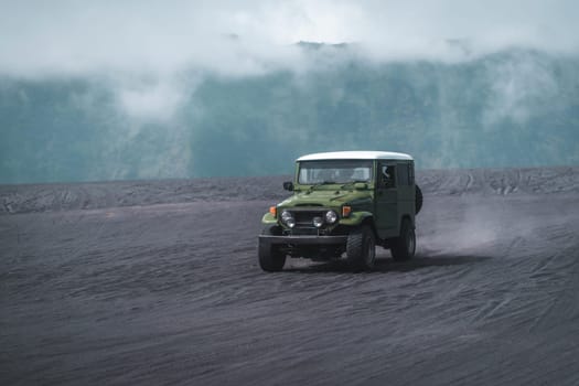 Travelling jeep driving trip in Bromo mount volcano territory. Vehicle journey in Semeru savanna field