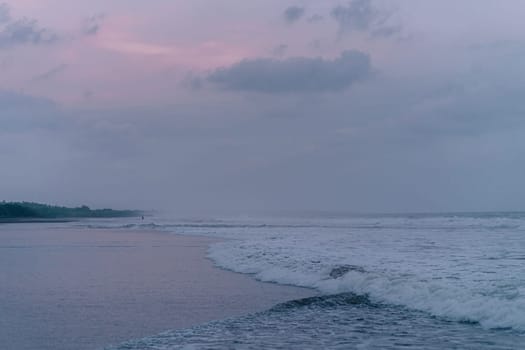 Majestic landscape photo of seaside with sunset sky. Tropical ocean beach with purple cloudy sky