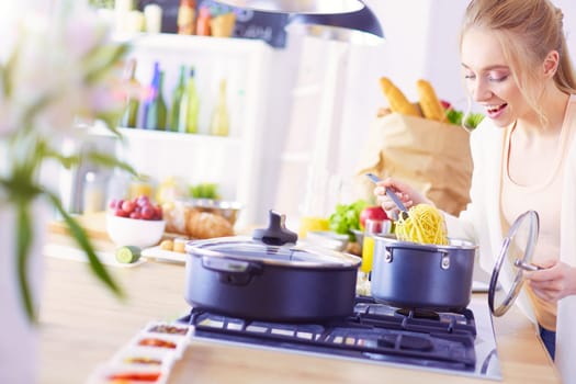 Beautiful young woman cooking in kitchen at home.