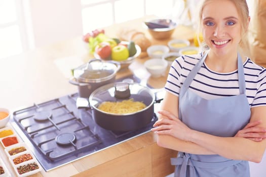 Young woman standing near desk in the kitchen .