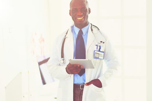 Portrait young african medical doctor holding patient's x-ray.