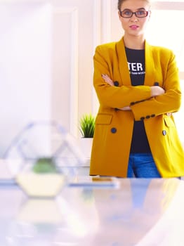 Portrait of a beautiful business woman standing near her workplace