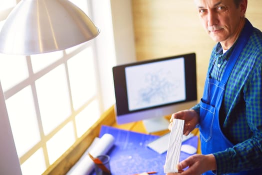 Architect working on drawing table in office.