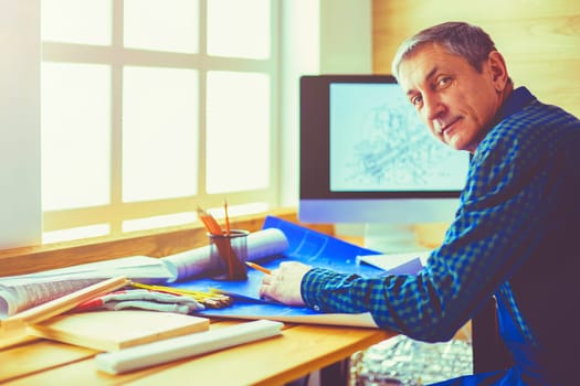 Architect working on drawing table in office.