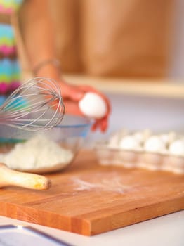 Woman is making cakes in the kitchen .