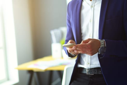 young businessman writing sms in his office.