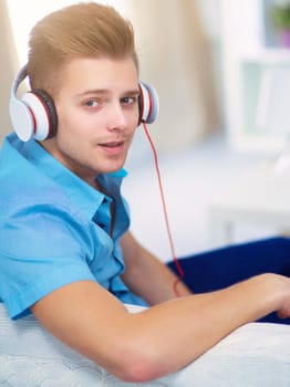 Man listening music with headphones at home.