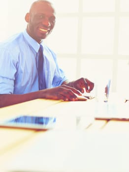 African american architect working with computer and blueprints in office.