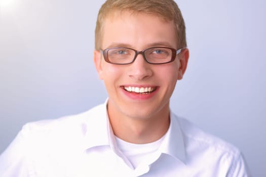 Portrait of young man sitting on gray background