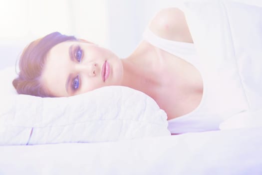 Young beautiful woman lying in bed