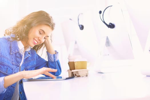 Smiling woman drinking coffee and using tablet in the cafe