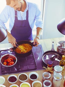 Man preparing delicious and healthy food in the home kitchen.