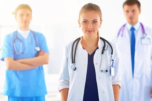 Attractive female doctor in front of medical group .