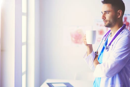 Young and confident male doctor portrait standing in medical office