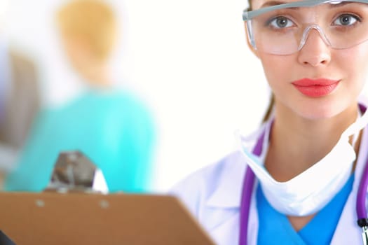 Woman doctor standing with folder at hospital .