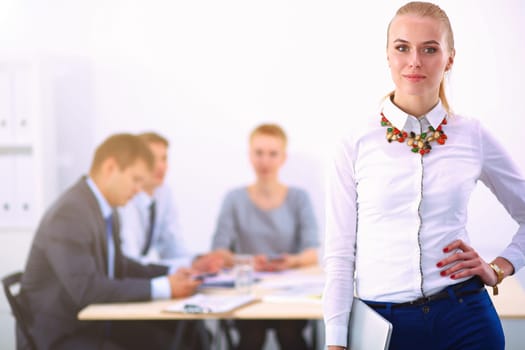 Portrait of a young woman working at office standing .