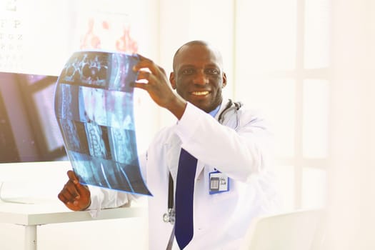 Portrait young african medical doctor holding patient's x-ray.