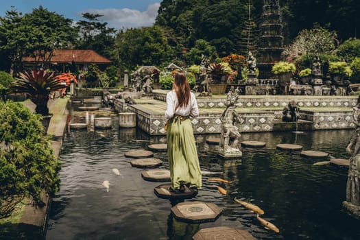 Girl walking in Saraswati temple water. Pura Taman Kemuda Saraswati, Ubud water palace