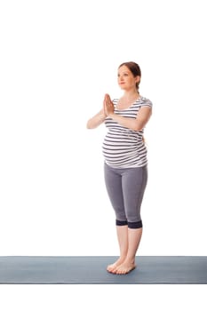 Pregnancy yoga exercise - pregnant woman doing yoga asana Tadasana Mountain pose with namaste isolated on white background