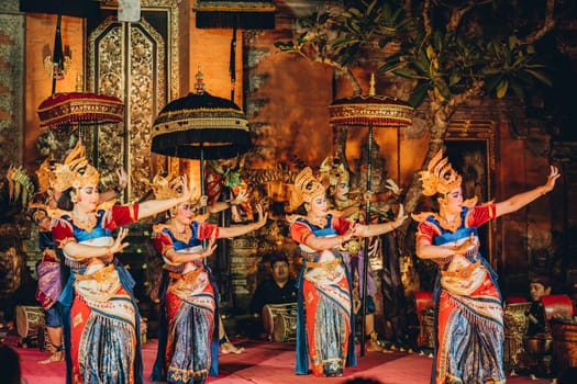 UBUD, BALI, INDONESIA - FEBRUARY 10, 2023: Traditional dance Legong and Barong in Ubud Palace, Balinese dance show with colorful dressed artists. Traditional balinese religious ritual performance