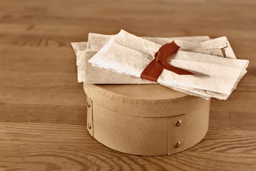  Old  letters tied with  ribbon on box on wooden table  , the past memories