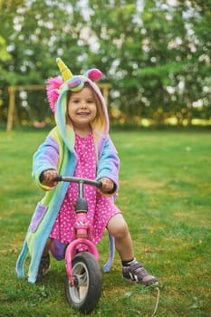 Adorable child riding a bike in the garden.