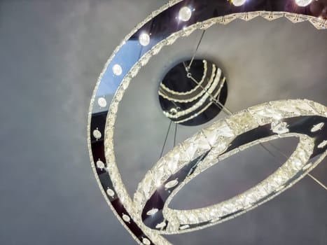 bright three circles one bigger than another with crystal clean stones with shine and light inside big luxury modern lamp.