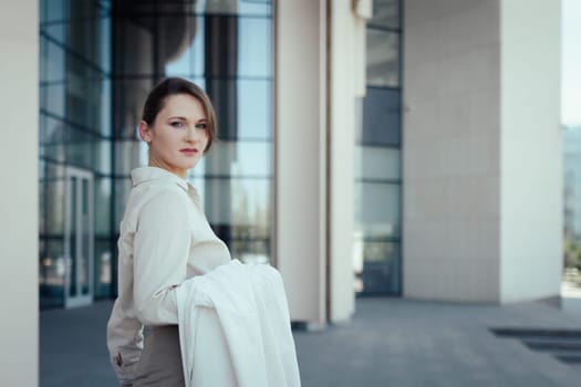 Confident stylish European business woman 30 years old against the backdrop of an office business building.