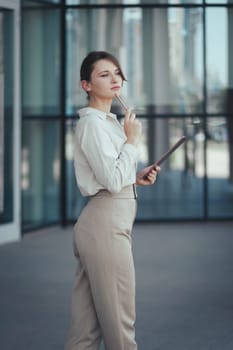 Business portrait of a startup woman with a tablet in her hands, vertical.