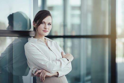 Portrait of a young successful caucasian business woman in front of a modern office building, copy space.