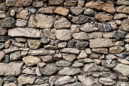 Old background of natural stones wall of different sizes.