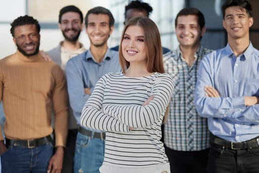 Smiling businesswoman looking at camera together with colleagues in the background