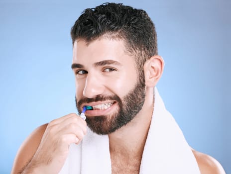 Studio portrait, man and toothbrush for teeth, dental wellness and healthy smile, mouth and cleaning. Happy male model, oral care and fresh breath for gums, dentistry and hygiene on blue background.