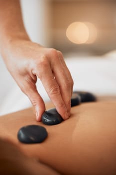 Hot stone therapy, massage and relax in a luxury spa resort for wellness treatment, relaxation therapy with hand and organic healing. Woman in a beauty salon, natural skincare and body health energy.