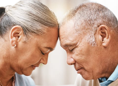 Face, love and trust with a senior couple in their home, touching heads in support or solidarity together. Relax, peace or romance with a mature man and woman bonding in their house during retirement.