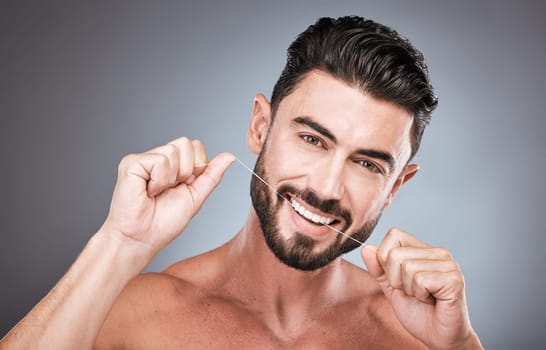 Floss, dental wellness and portrait of man in studio for beauty, healthy body and hygiene on background. Male model, tooth flossing and cleaning mouth for facial smile, fresh breath and happy teeth.