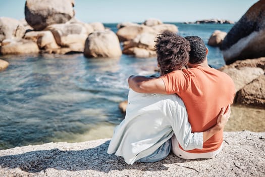 Couple, love and hug on beach for relax travel vacation together or bonding on ocean sand with summer sunshine. African man, woman and calm holiday or loving romance date by the sea water outdoors.