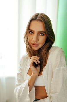 Portrait of attractive lovely girl wearing crop top and shirt posing over green studio background close up