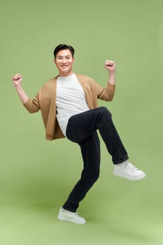 Portrait of young male cheerful confident and excited jump in air and smile at studio