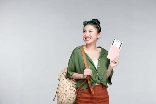 Young woman traveler with backpack and passport with ticket isolated on white