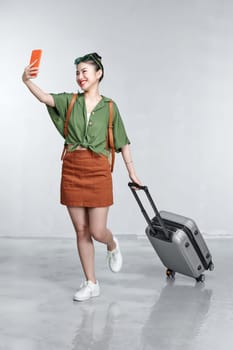 Happy Traveler woman with backpack, passport and boarding tickets take a selfie by smartphone
