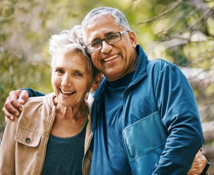 Hiking, portrait and romance with a senior couple hugging in the woods or nature forest together in summer for a hike. Fun, joke and bonding with a mature man and woman enjoying retirement outdoor.