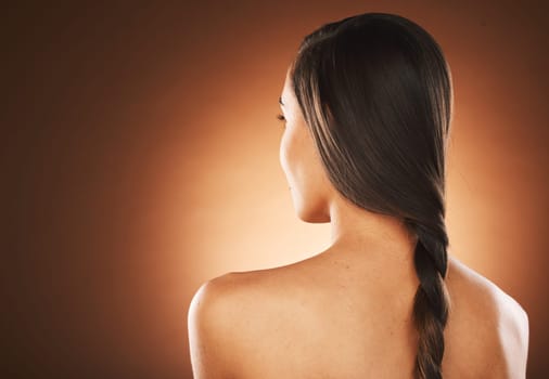 Woman, back or hair style on orange background in studio in keratin treatment marketing, balayage growth advertising or self care routine. Model, texture or healthy brunette color on aesthetic mockup.